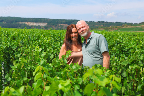 Couple standing together in Burgundy vineyards, enjoying summer travel, wine culture, nature, and scenic countryside surroundings.