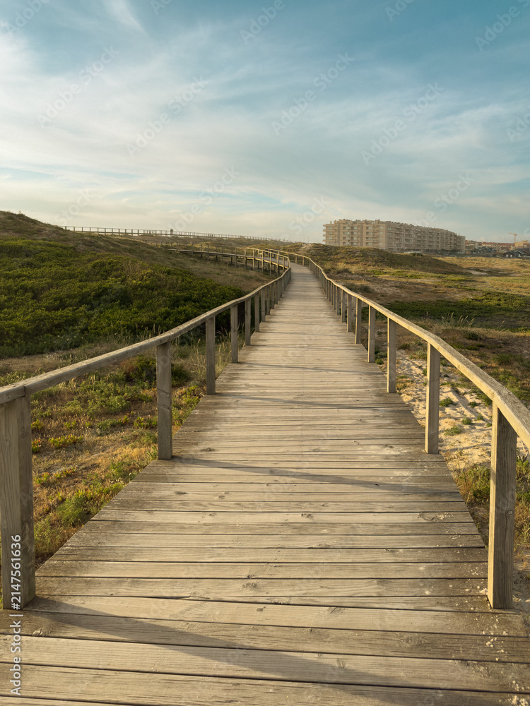 Fototapeta premium Wooden boardwalk path through dunes in Furadouro
