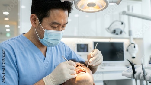 Medical - Asian dentist examining a patient in a dental clinic