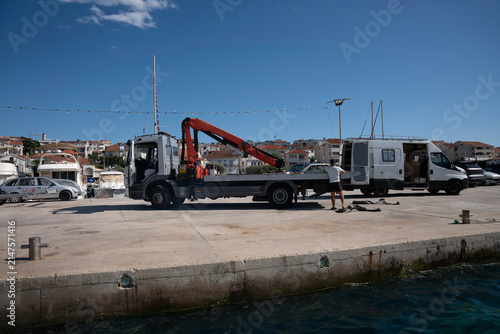 Obraz na plátne Shipyard harbor view with a floating drydock, and a truck crane parked on a coastal pier