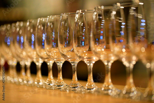 Obraz na plátně A row of neatly arranged empty wine glasses, inside the bar