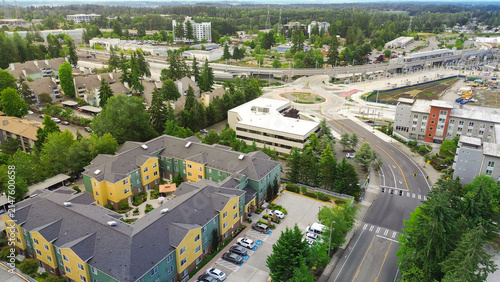 Transit station development zone and urban commercial blocks intersect near S 317th Street corridors. Overhead capture highlights light rail, parking garage, solar panels. Federal Way, WA