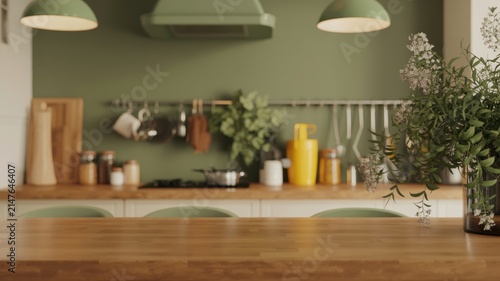 Modern green and wood kitchen interior with wooden table, flowers and cooking accessories