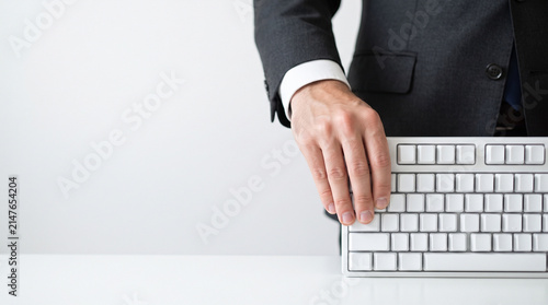 Close-up of an employee's hand holding a computer keyboard; company; work activities