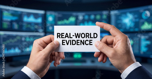 Real-world evidence concept held by businessman in office with digital analytical data monitors displaying charts and glowing blue graphs background