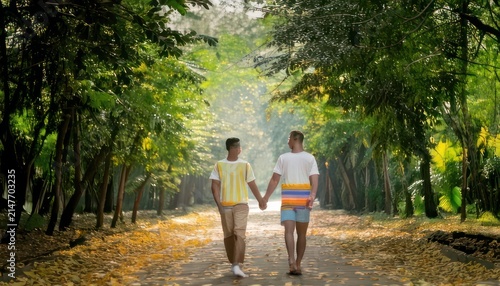 Couple walking hand in hand forest.