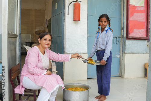 Fotografía Indian teacher serving nutritious mid-day meal to a female student