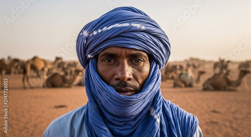 Man in traditional blue turban standing in arid desert landscape