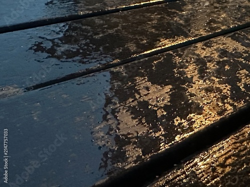Close-Up of Rain Water on a Wooden Table Featuring Natural Raindrops, Wet Wood Texture and Outdoor Surface Detail