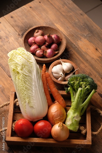Fresh vegetable in the wooden tray. Broccoli, carrot, tomato, Chinese cabbage, garlic, shallot, onions