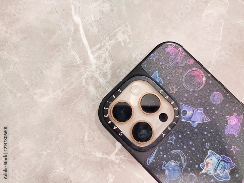 Close-up shot of a modern smartphone featuring a triple-camera module protected by a printed galaxy and space pattern phone case. Perfect for mobile technology, smartphone accessories, modern gadgets,