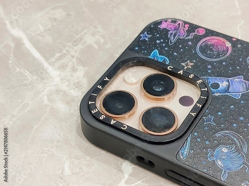 Close-up shot of a modern smartphone featuring a triple-camera module protected by a printed galaxy and space pattern phone case. Perfect for mobile technology, smartphone accessories, modern gadgets,