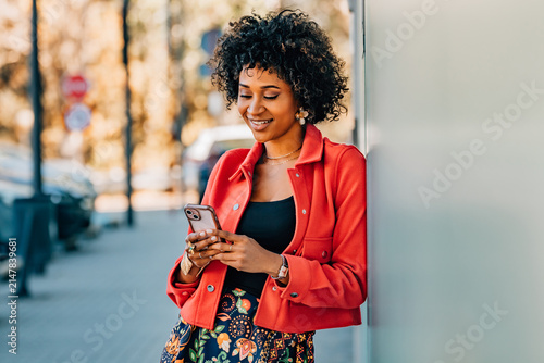 woman on the street looking at her cell phone