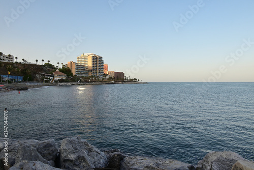 Strand mit Palmen und Hotels abends in Benalmadena, Spanien
