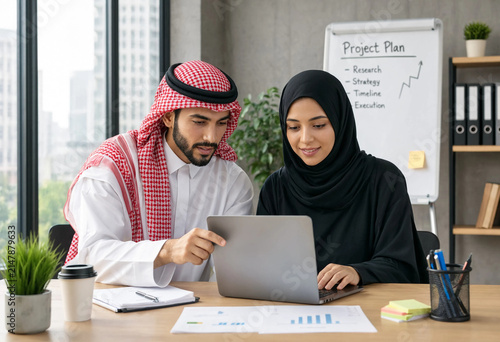 Arab man and woman collaborate over a laptop