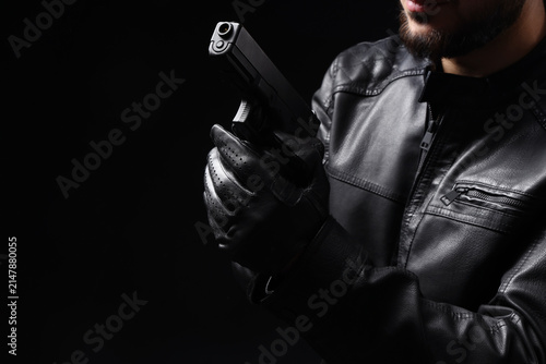 Cuadro en lienzo Man with gun on black background, closeup