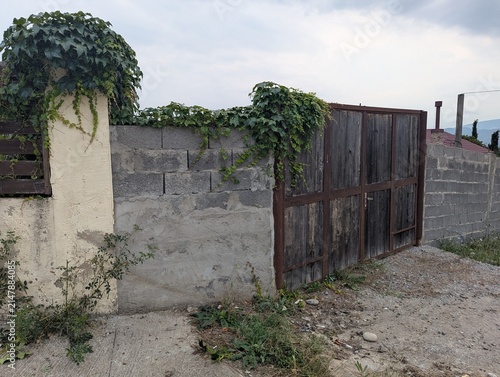 Фотография Old entrance gates and a concrete fence at a country property
