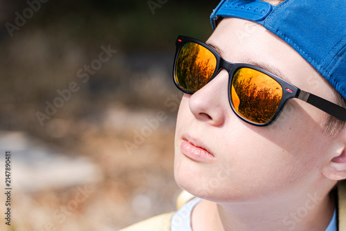 Canvastavla Teenager boy in sun glasses with sky reflection