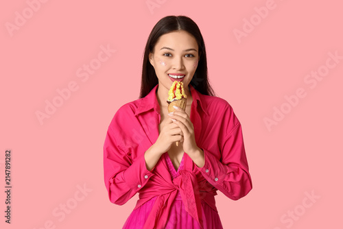 Beautiful Asian woman with mango ice-cream on pink background