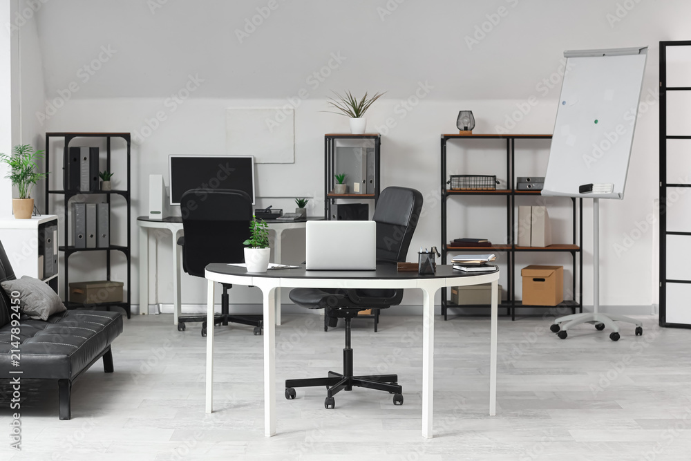 Fototapeta premium Interior of modern office with tables and shelf units