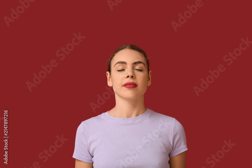 Beautiful young woman meditating on red background. Zen concept