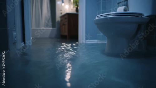 Flooded Bathroom at Night with Reflecting Light on Water Surface