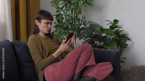 Young woman laughing and texting on smartphone