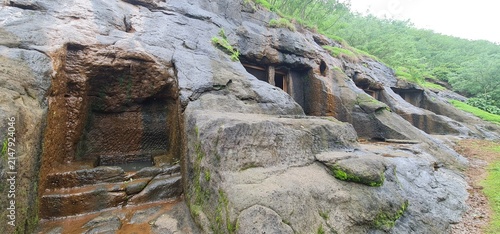 Exterior View of Ancient Rock Cut Facade and Wet Basalt Walls of Kuda Caves in Monsoon, Maharashtra