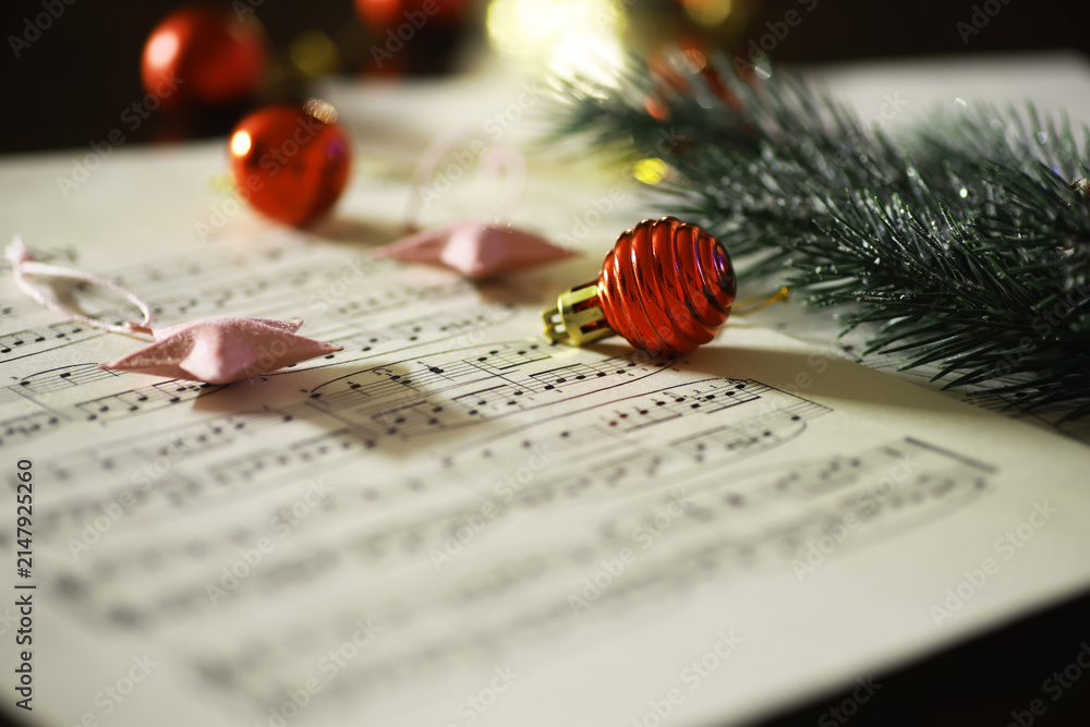 Obraz premium Christmas Sheet Music with Festive Ornaments and Pine Branch Decoration in Soft Focus