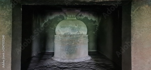 Monolithic Stone Stupa Inside Dimly Lit Cave Chamber at Historic Kuda Caves Archaeology Site