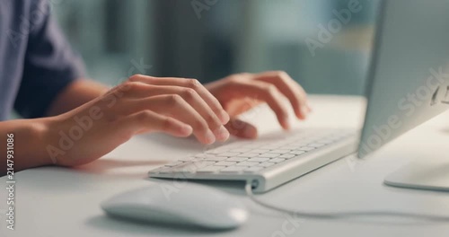 Person typing on computer keyboard, close up view of hands typing