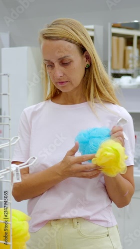 Woman Comparing Colorful Bath Sponges in Household Goods Store