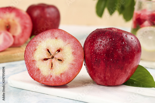 Принти на полотні Fresh Red Apples Cut in Half Showing Interior Flesh and Seeds on White Cutting B