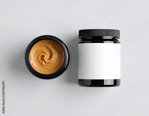 Overhead shot of two jars, one open with swirl of butter, the other closed with label