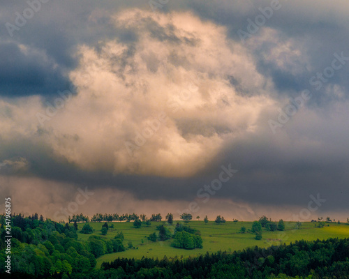Obraz na plátne Heavy dark storm clouds gathering dramatically above a distant rural horizon and