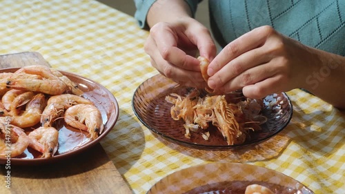 Food prep. Female hands peeling boiled tiger shrimp. Eating seafood.