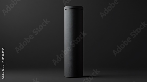 Tall, cylindrical black cardboard tube standing upright against a dark background