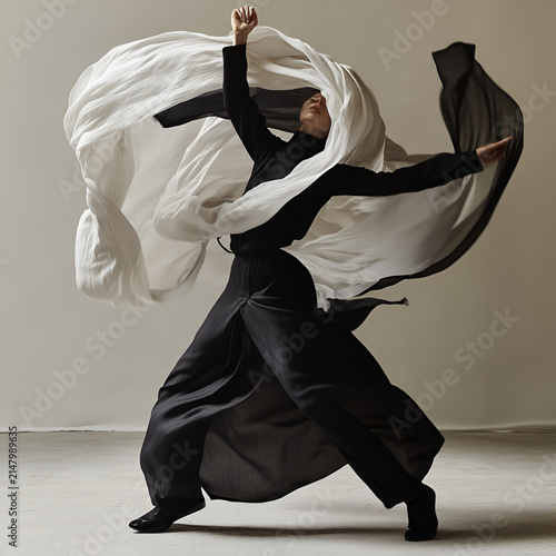 Elegant dancer in flowing attire expressing movement and emotion in a beautifully lit studio environment