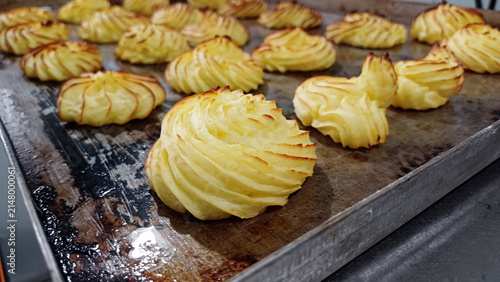 Freshly baked duchess potatoes with a crispy golden crust arranged on a baking tray. Homemade potato side dish prepared in the oven. Culinary concepts, restaurants, catering, holiday meals, 