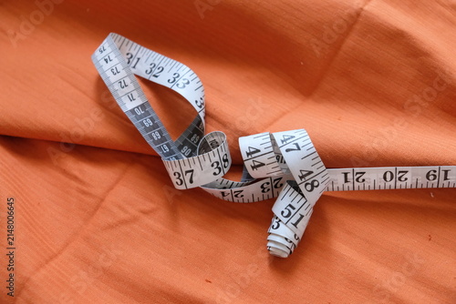 Close-up of a measuring tape over fabric, capturing the essential first steps of tailoring and creative craftsmanship