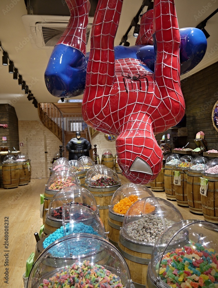 Fototapeta premium Spider-Man statue hanging over candy store barrels