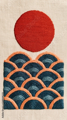 Hand-embroidered textile art featuring a bold red sun above stylized ocean waves in blue and orange threads on neutral fabric.