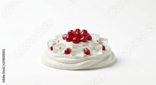 Distant shot of 5 to 10 pomegranate seeds and aloe vera cubes nestled on thick white essence cream