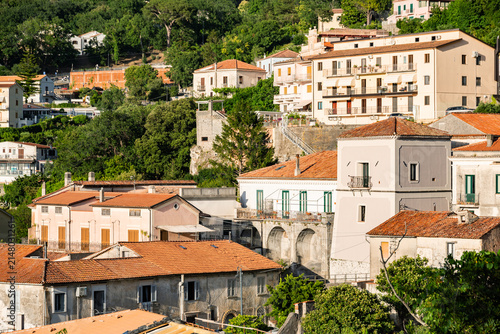 view of Maratea framed by dense forests and dramatic mountain slopes. Warm Mediterranean sunlight , Italy