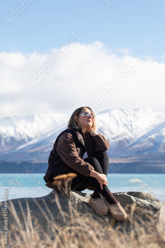 Woman relaxing on a rock with mountain landscape in the background