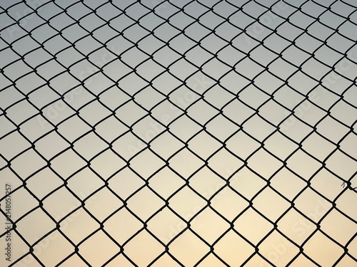 Foto Silhouette of a chain link fence against a clear sky