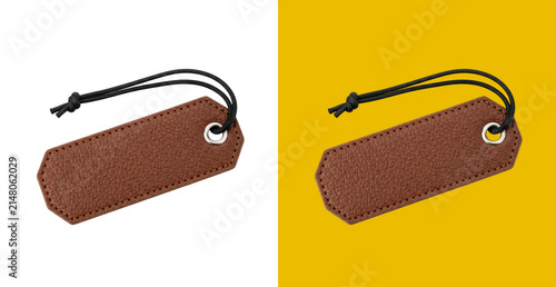 Small brown leather gift tag with a black string loop for product pricing and labeling isolated on a simple colored background