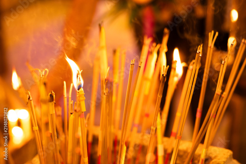 Burning incense and candles with soft rising smoke, creating a calm sacred atmosphere. Ideal for religion, culture, ritual, and meditation scenes