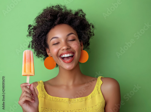 Woman enjoying a popsicle with a green background in a bright summer setting