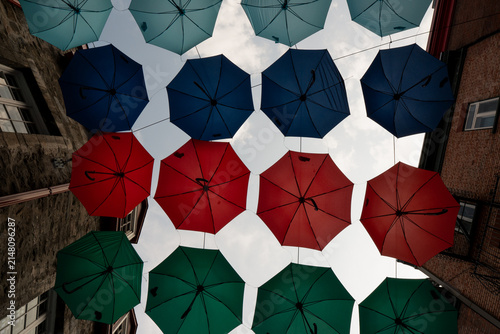 Foto Colorful umbrellas hang above a street in a city